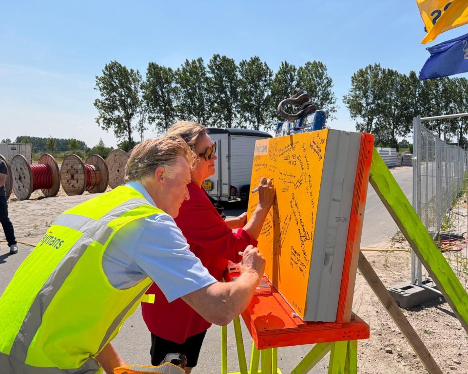 Wethouder en Erik Vos schrijven boodschap op kzst-blok