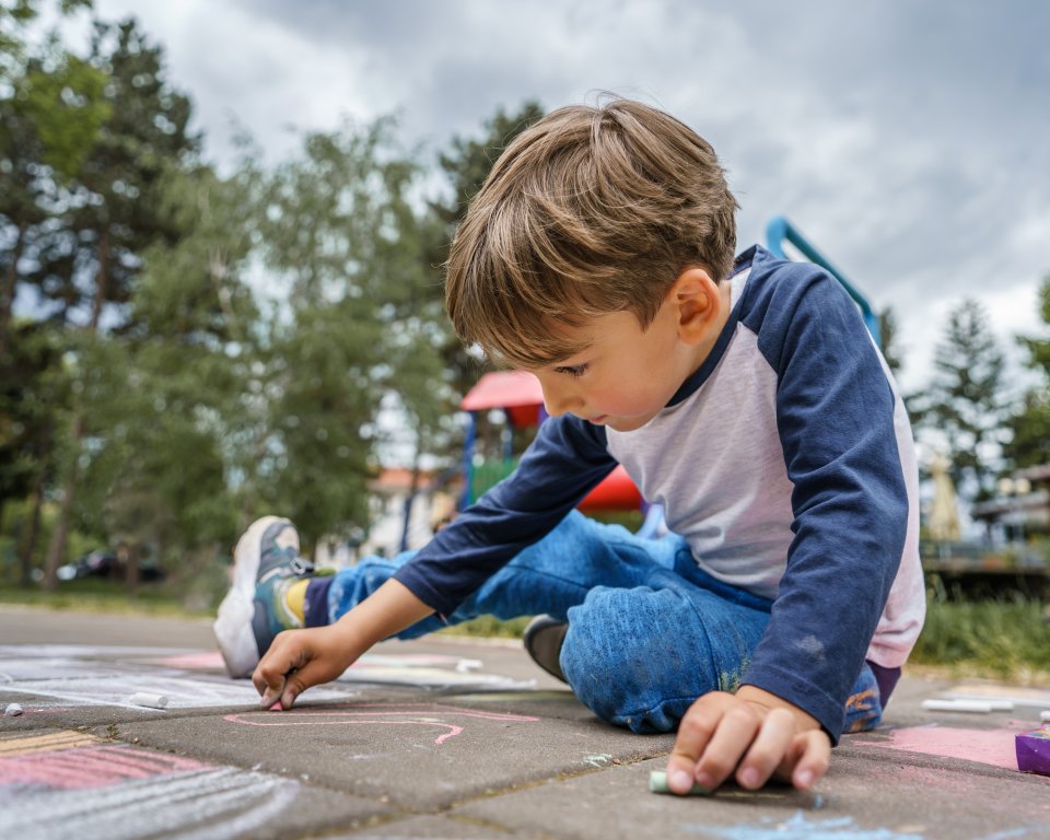 Jongen aan het stoepkrijten