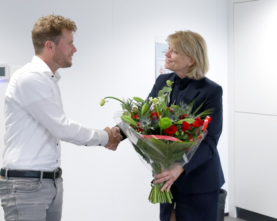 Wethouder Marianne Klein met bos bloemen voor Iteq