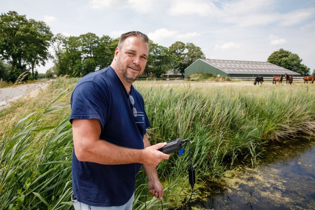 Harry staat langs de sloot de waterkwaliteit te meten