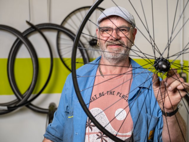 Sjonnie Buiter die de weesfietsen opknapt en waar nodig van nieuwe onderdelen voorziet