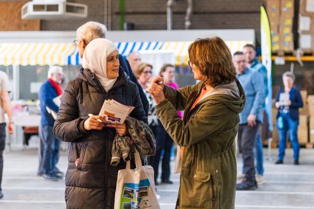 Twee inwoners met elkaar in gesprek tijdens de Kansenmarkt.