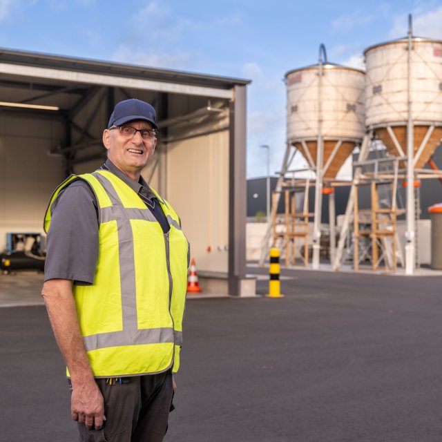 René Douwes op het terrein van de buitendienst, met op de achtergrond de twee zoutsilo's
