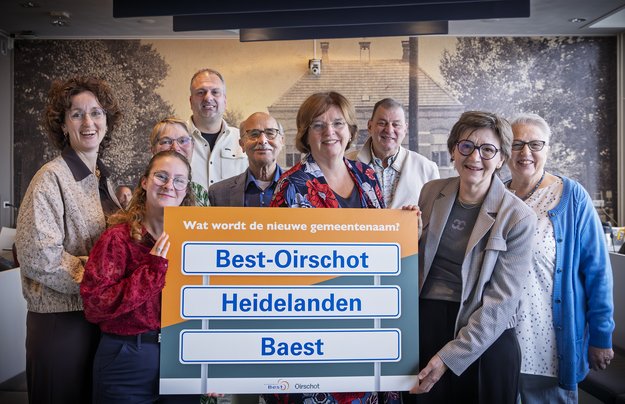 De naamgevingscommissie en burgemeesters van Best en Oirschot houden een bord omhoog met daarop: Best-Oirschot, Heidelanden en Baest.