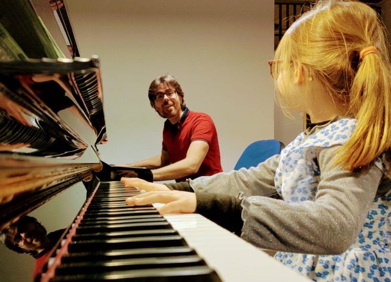 Lorenzo Martínez en een leerling aan de piano.