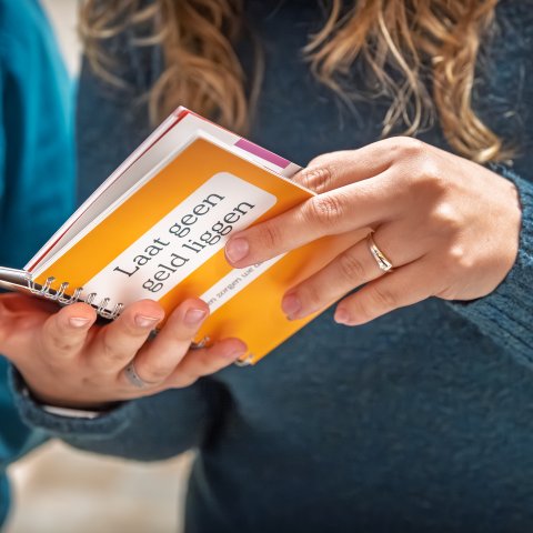 Iemand leest in het boekje. 