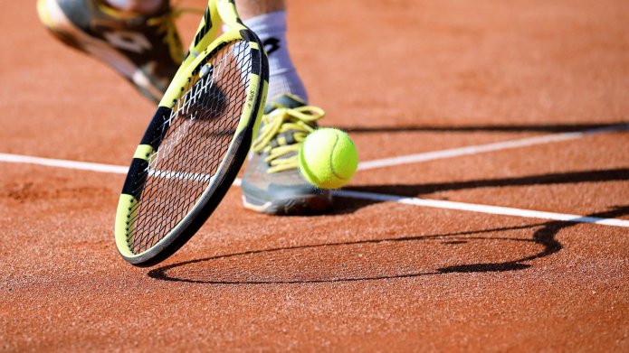 Tennisser met tennisbal en racket