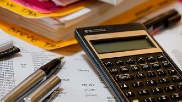 Belastingpapieren, pen en rekenmachine op tafel 
