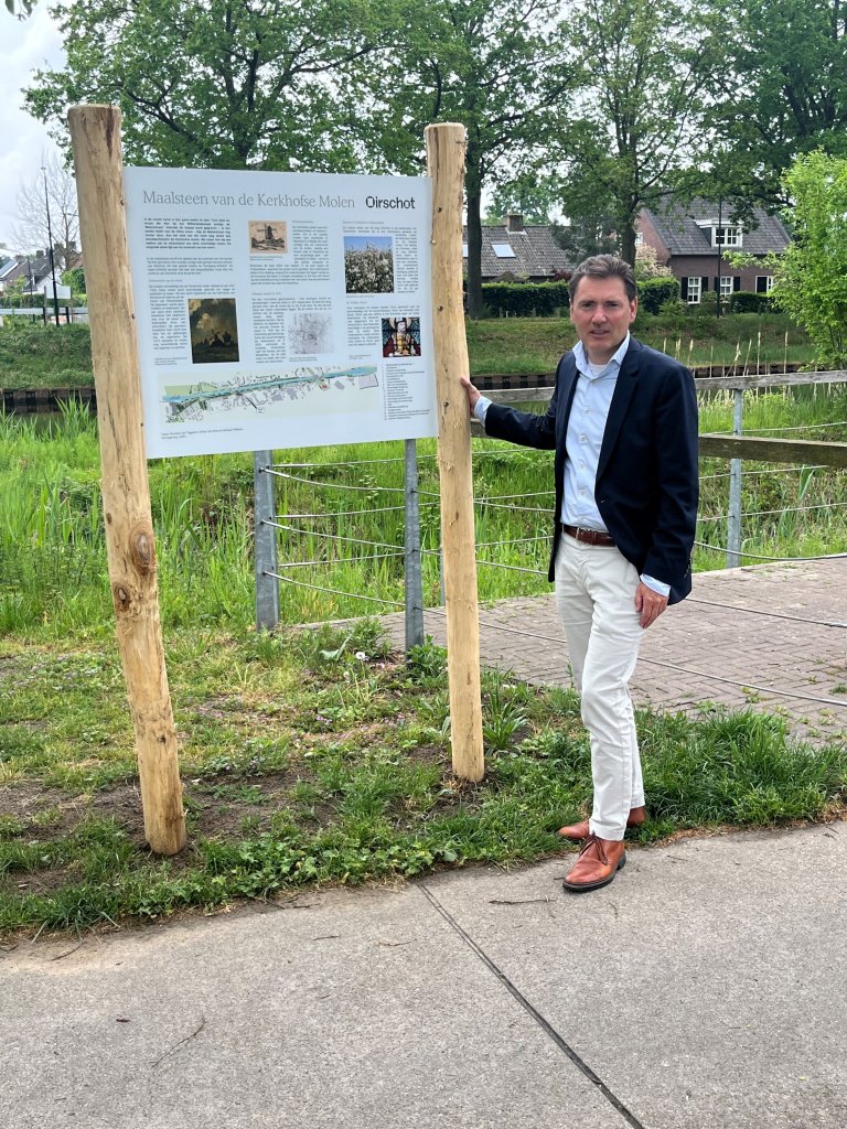 Wethouder Joep van de Ven bij de onthulling van de molensteen en de bijbehorende borden.
