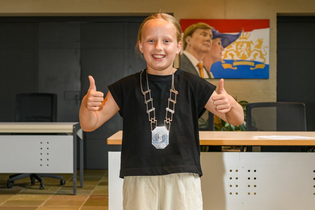 De nieuwe jeugdburgemeester met ambtsketting in de raadzaal van Oirschot.
