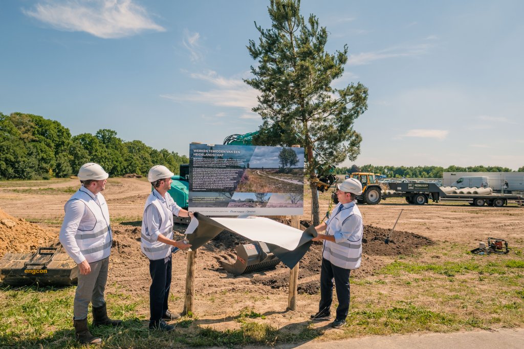 Medewerkers van SDK Vastgoed onthullen een bord bij de boom die is geplant als symbolisch startsein voor de bouw van het nieuwe service warehouse.