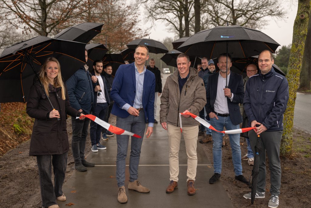 Wethouder Paul van den Biggelaar opent officieel het fietspad en knipt een lint door.