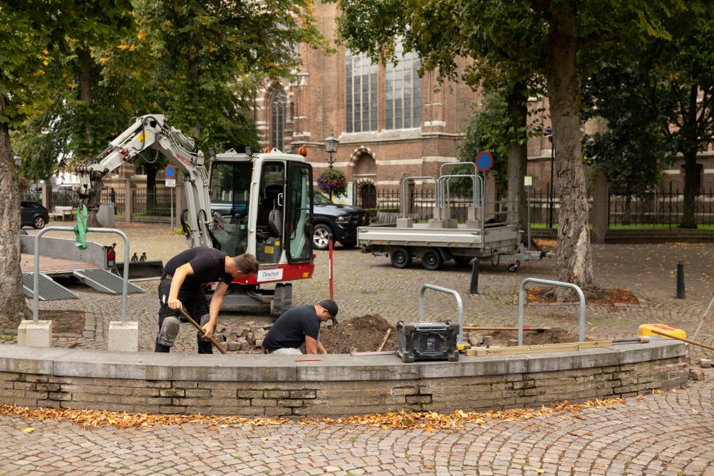 Mannen plaatsen fietsnietjes op de markt in Oirschot.
