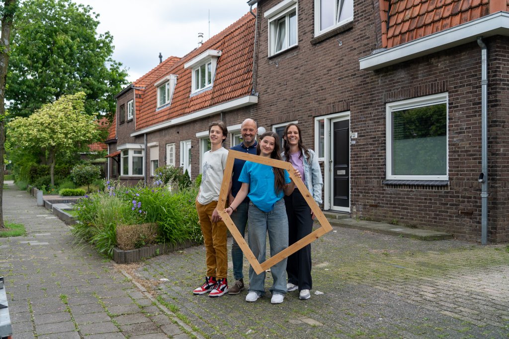 Een familie staat voor een duurzaam huis