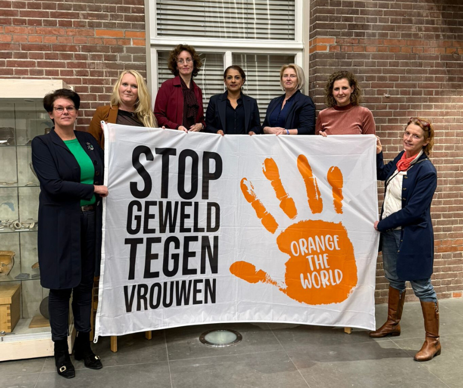 Vrouwelijke college- en raadsleden van gemeente Oirschot houden de vlag van Orange the World omhoog. 