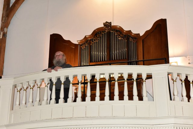 Peter van Dijk voor het 18e eeuwse kabinetorgel op het balkon van het Oude Kerkje te Middelbeers (Foto: Wil der Kinderen)
