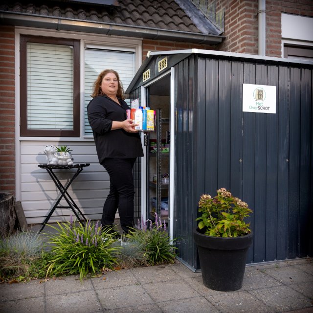 Patricia staat bij minimakastje Het OverSCHOT in haar voortuin. 