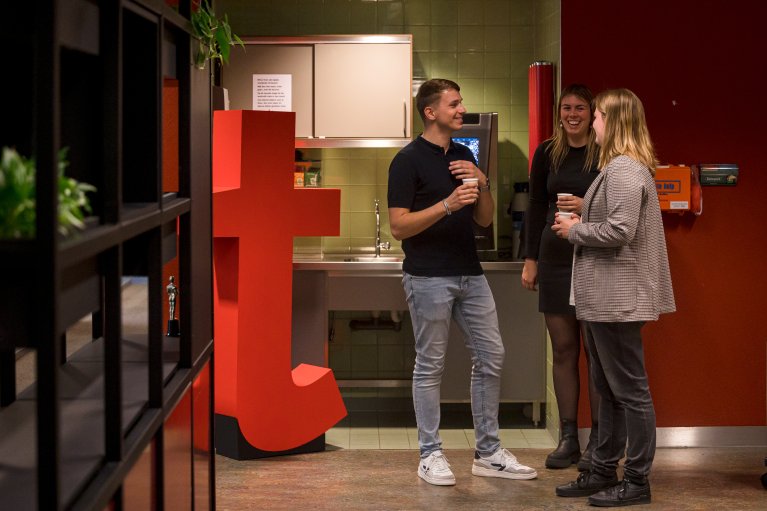 3 collega's drinken samen koffie en praten bij