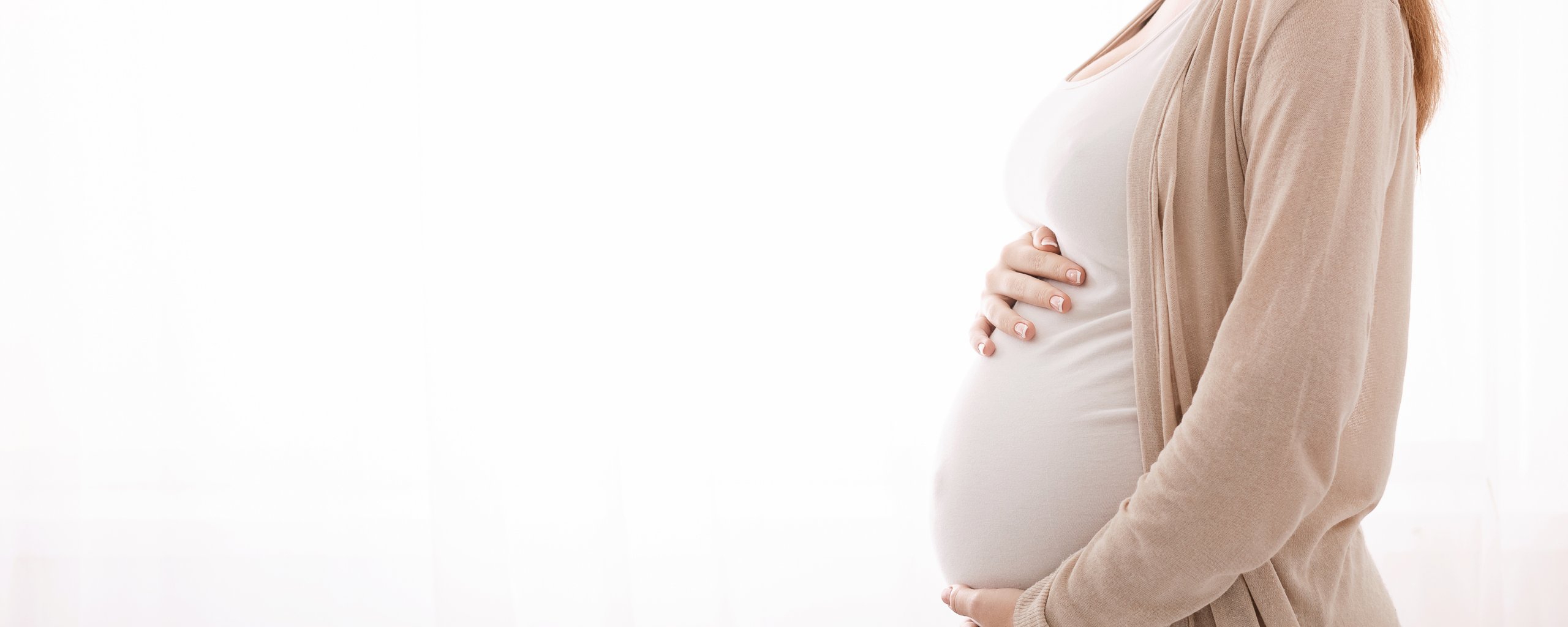 Zwangere vrouw met handen op buik