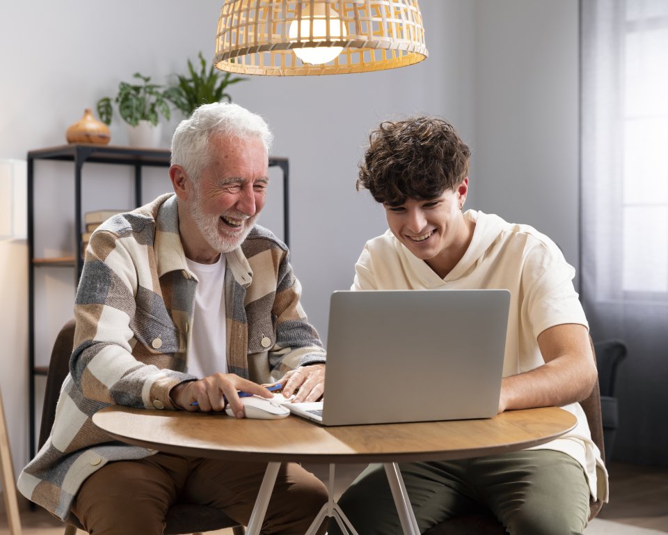 Man met jongere achter de computer