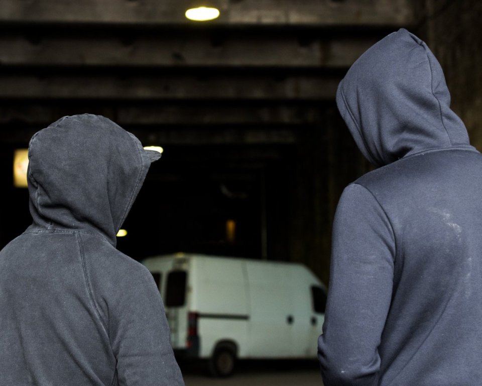 Criminelen in donkere hoodie in schuur