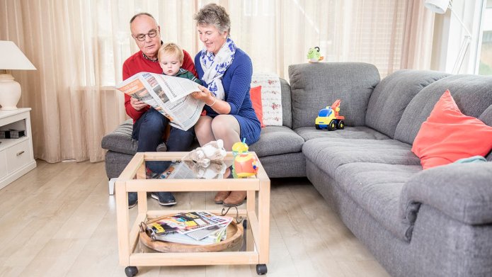 Opa en oma lezen krant met kleinkind