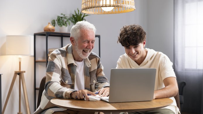 Man met jongere achter de computer