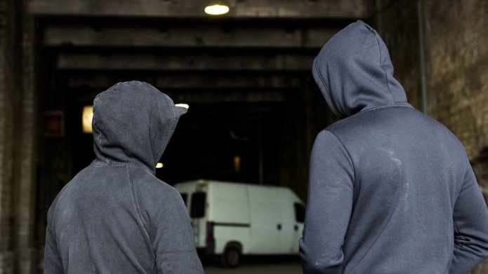 Criminelen in donkere hoodie in schuur