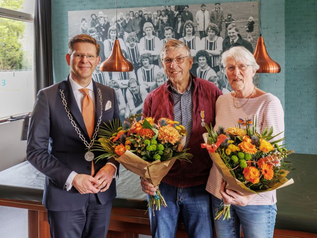 Burgmeester Werkman met twee personen die een lintje ontvingen tijdens de lintjesregen