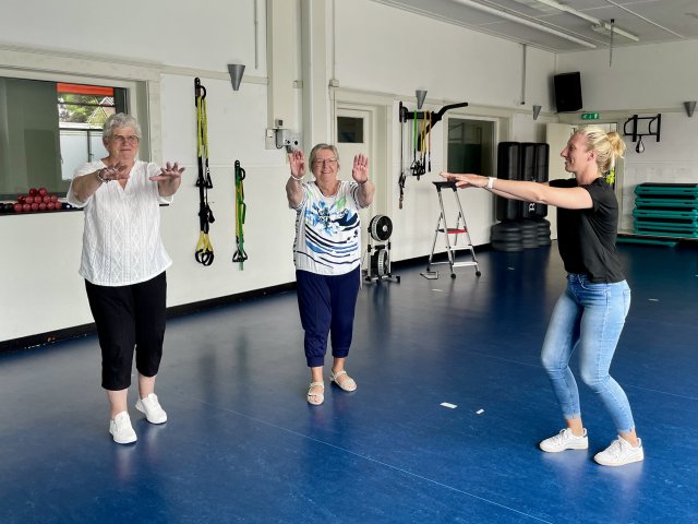 Er wordt een foto afgebeeld. Foto onderschrift: Anita (links) en Bep (midden) dansen samen met instructrice Anne-Carina de ‘balansdans’.