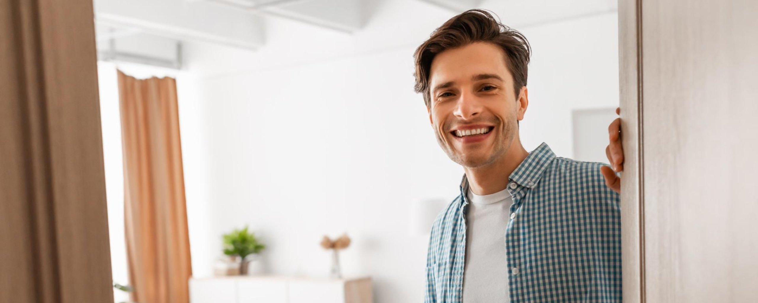 Man staat in de deuropening van zijn appartement