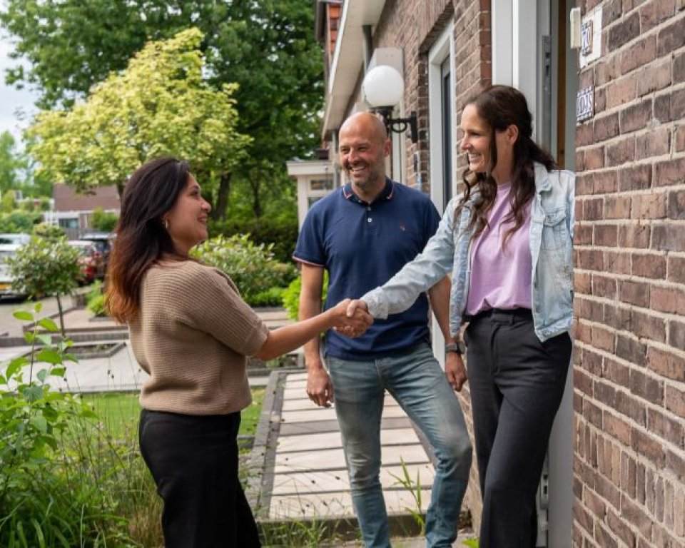 Bewoners van duurzaam huis verwelkomen bezoekster 