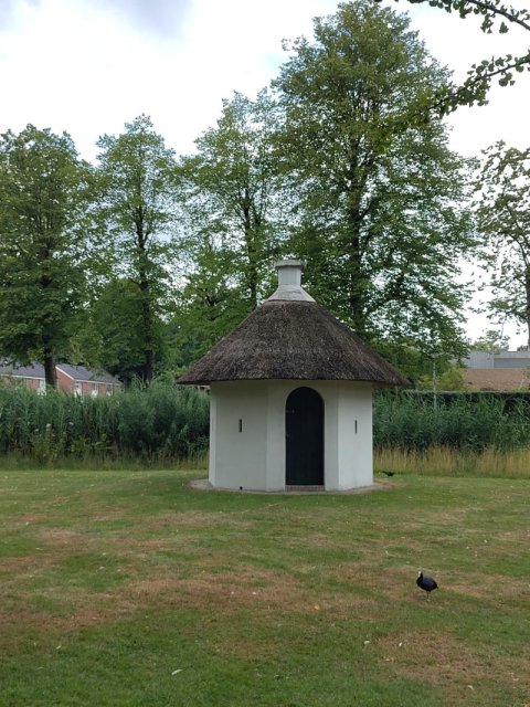 Zicht op het witte bleekhuisje in het park
