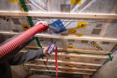 Installateur brengt ter isolatie houtvezels aan in de dakbedekking