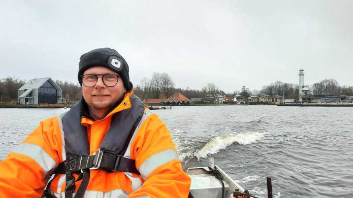 Uitvoerder Henk Oosterhuis in een boot op het Paterswoldsemeer