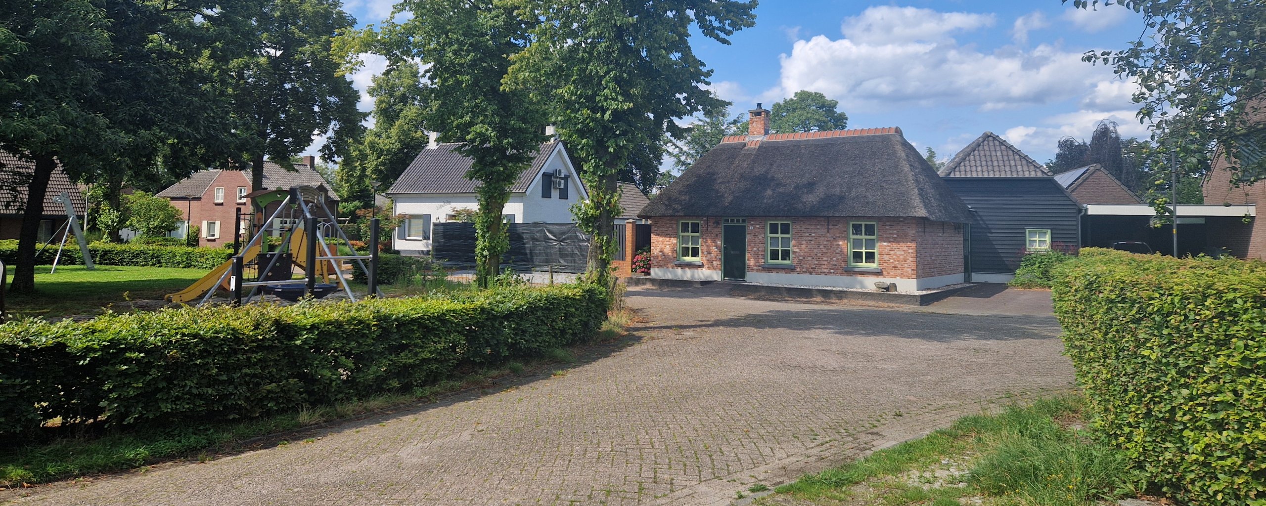 Casteren-Zuid, straat Kerkeneind met het straatbeeld van een historisch pand, speeltuin en groene omgeving