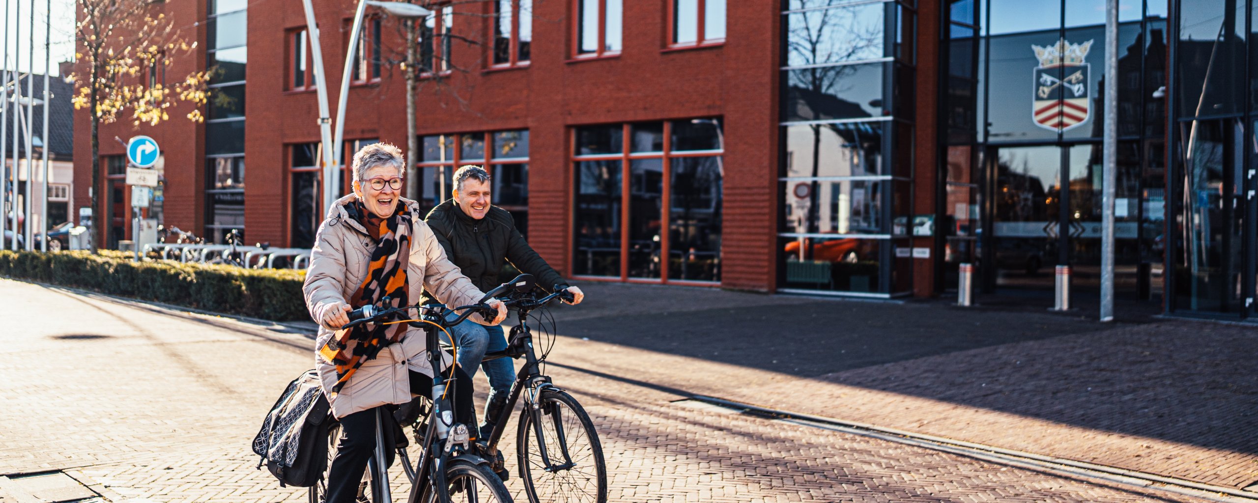 Twee collega's op de fiets voor het gemeentehuis