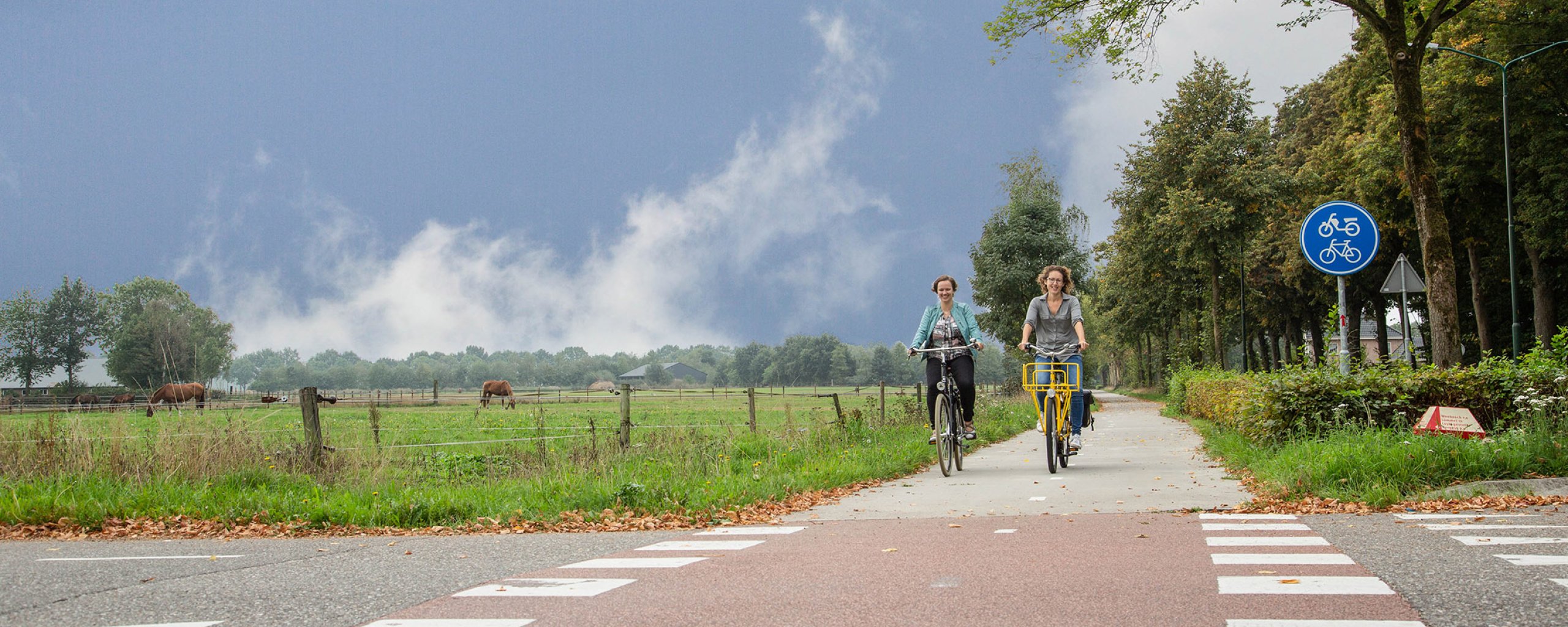 Twee vrouwen fietsen over een fietspad