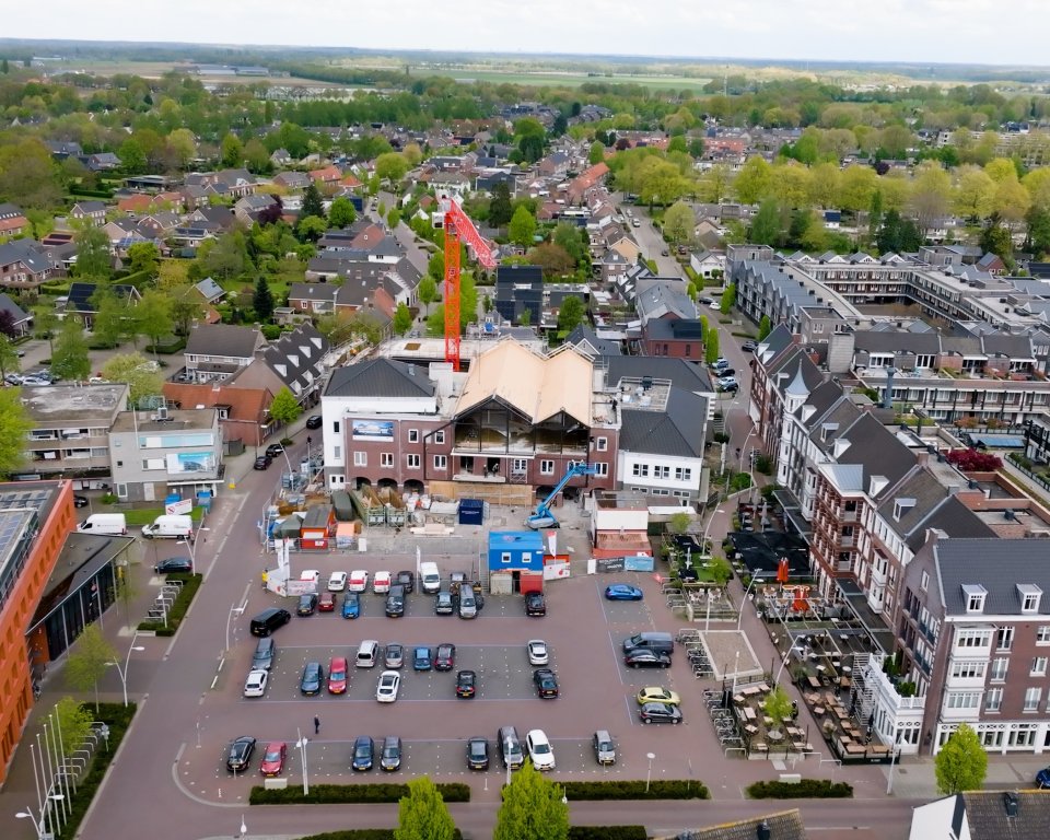 Marktgebied in Bladel vanuit de lucht met gemeentehuis, parkeerplaats en de bouw van het nieuwe ontmoetingscentrum Bruis