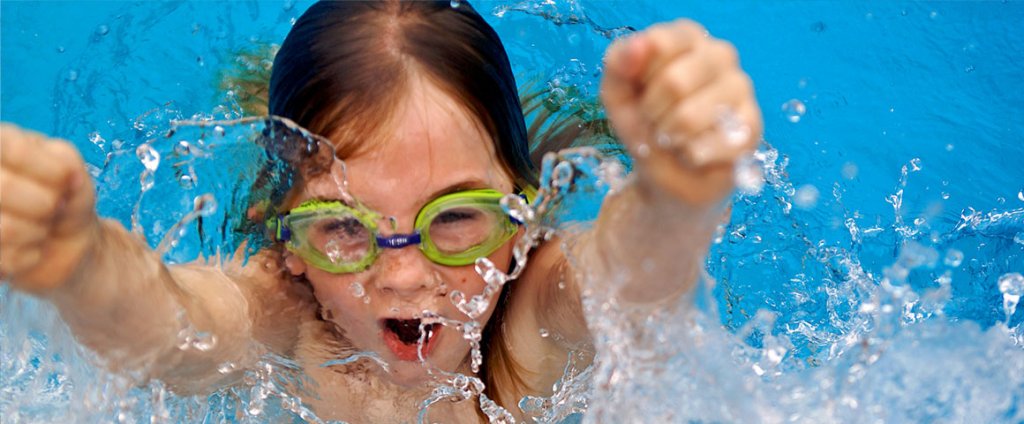 een meisje met zwembril juicht in het water