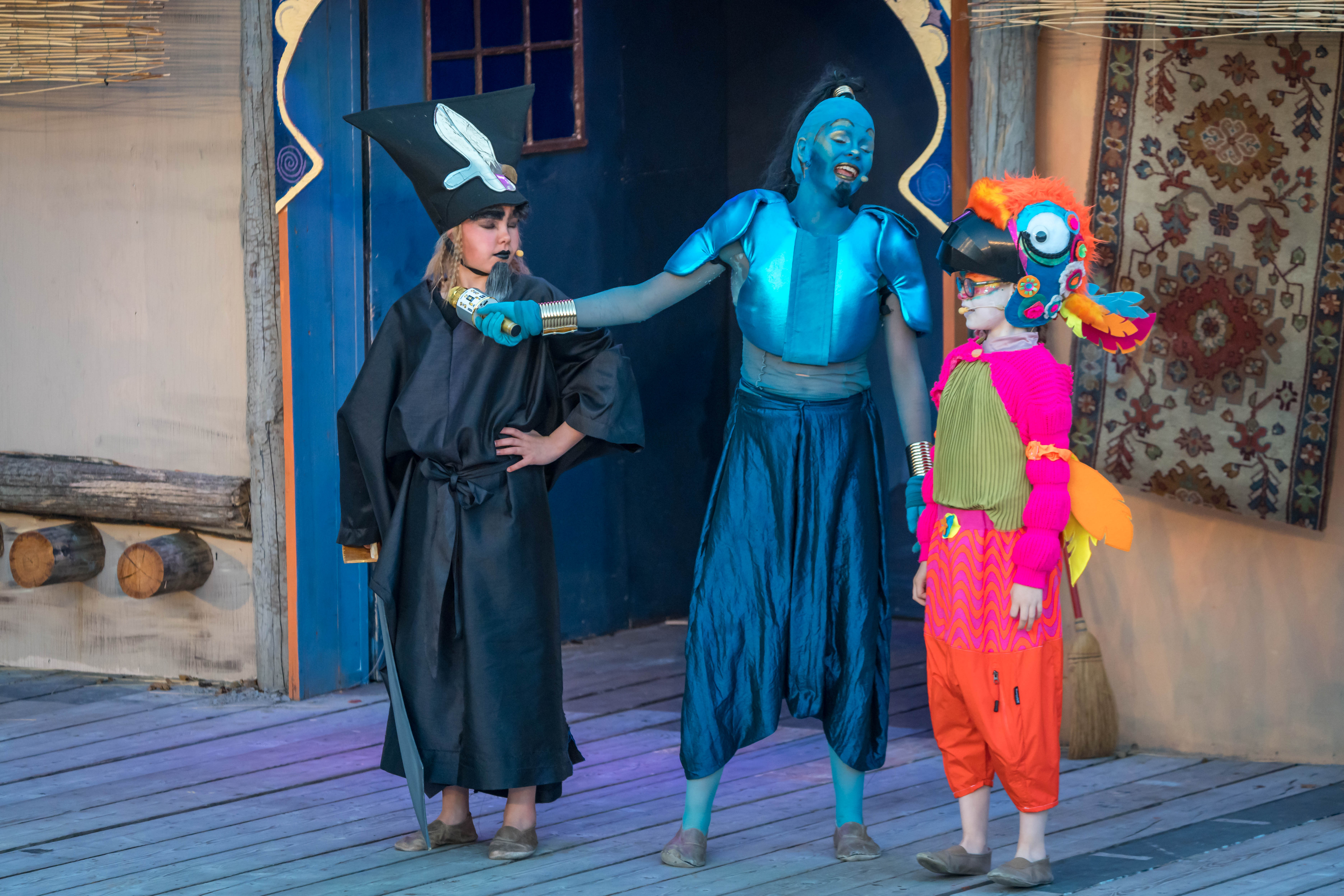 Kinderen spelen een scène uit Alladin met de Geest uit de fles en nog twee figuren.