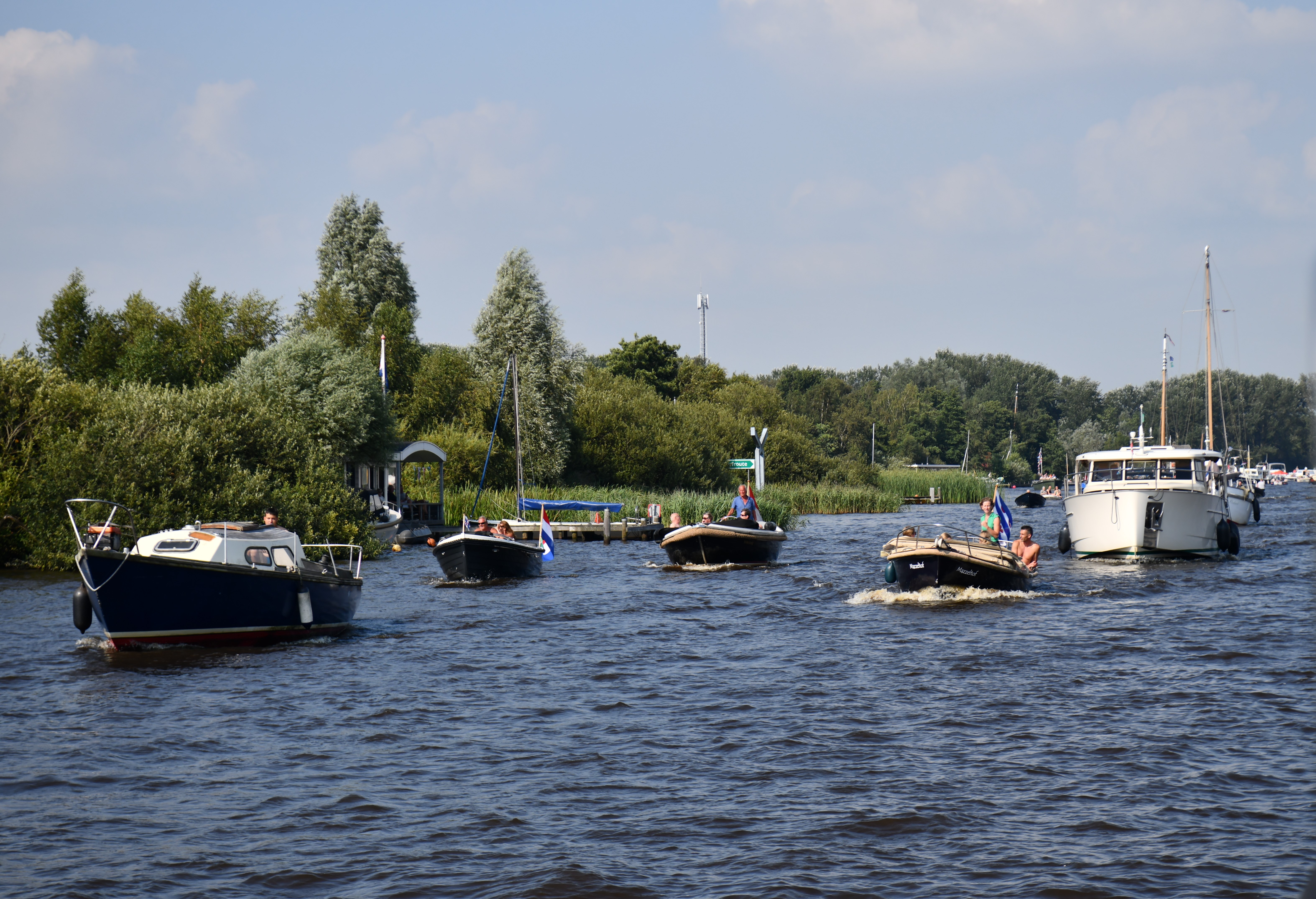 Meerdere plezierbootjes varen op het water.