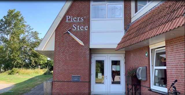 Een gebouw waar met zilverkleurige letter Piers' Stee op staat met daaronder een zwaard