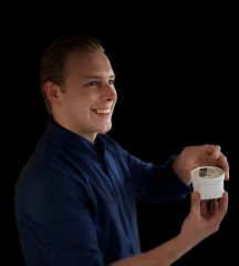 Een man staat met een kuipje ijs van SKYLD op de foto.