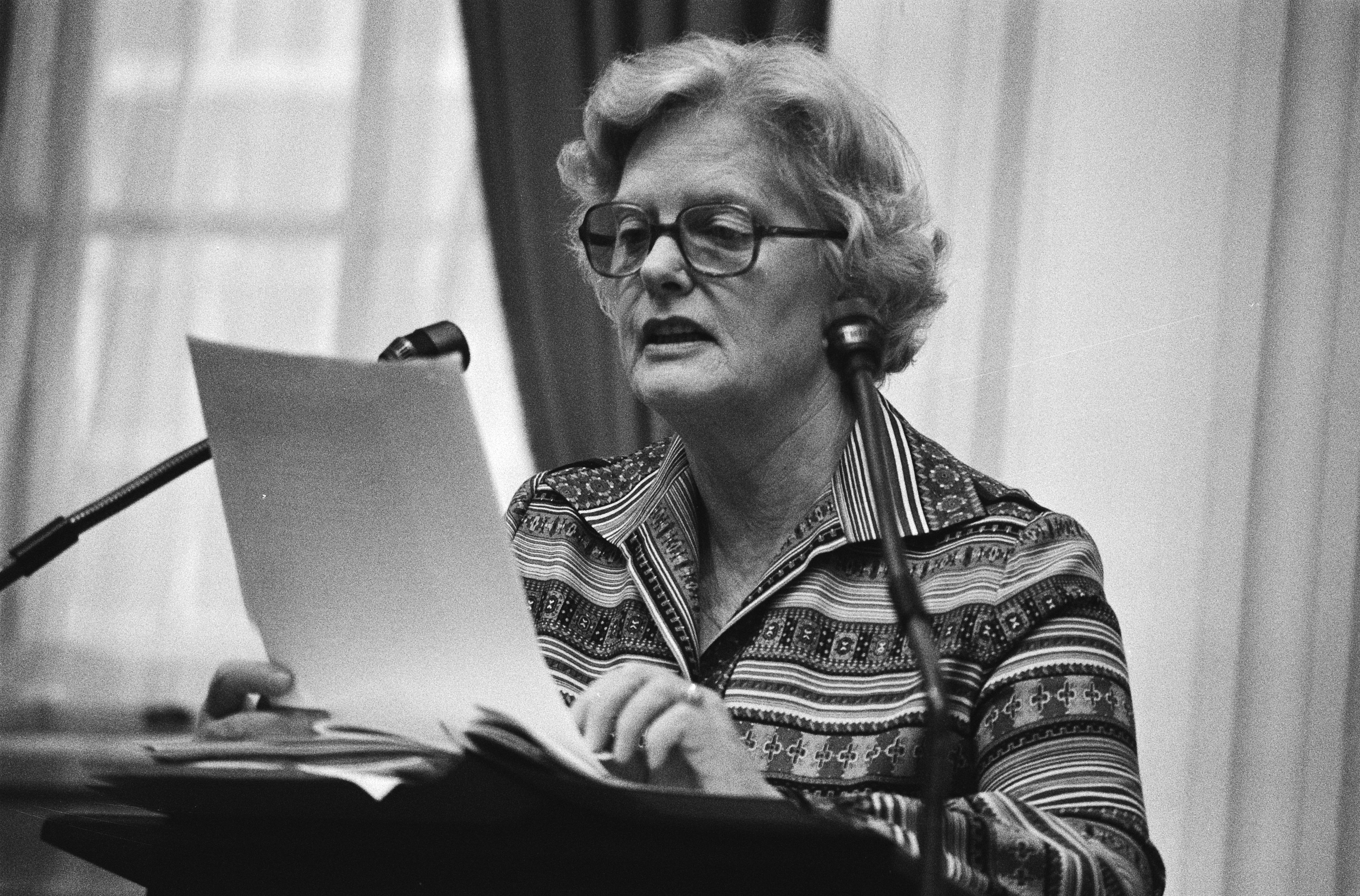 Zwartwitfoto van Els Veder-Smit die staat te spreken in de microfoon.