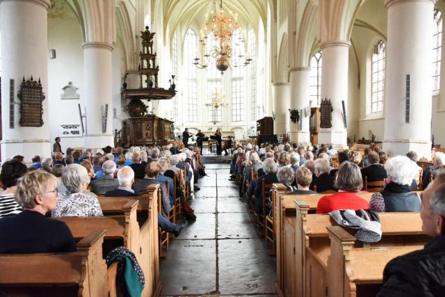 Martinikerk in Bolsward met publiek in de kerkbankjes