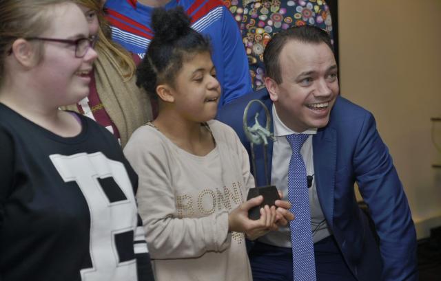 Gedeputeerde Sander de Rouwe poseert met kinderen en hun winnende trofee