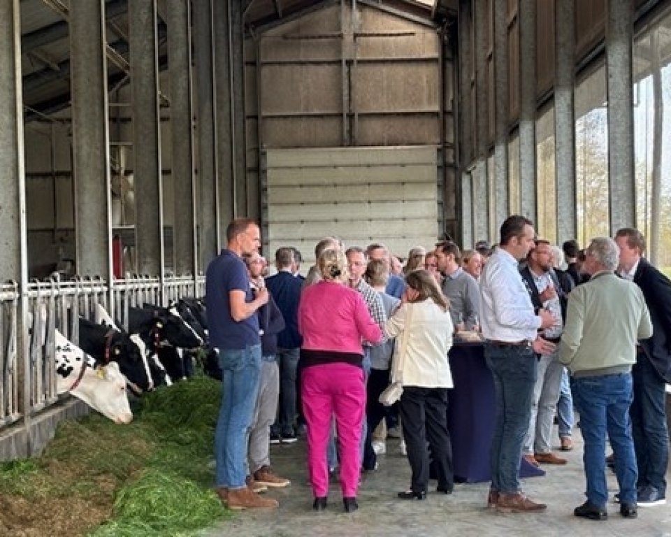 een groep personen in een koeienstal