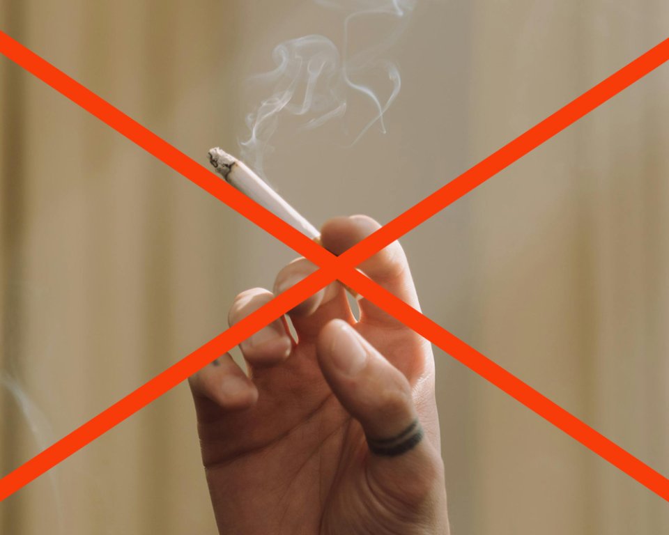 sigaret in een hand met een rood kruis erdoor