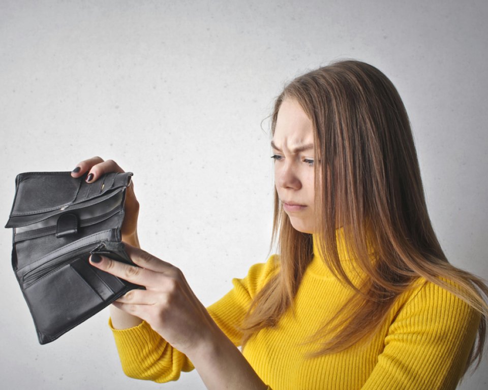zorgelijk kijkende vrouw met lege portemonnee